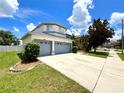 Spacious home showcasing a large driveway leading to a two-car garage, surrounded by lush greenery at 11122 Kempton Vista Dr, Riverview, FL 33579