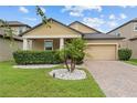 Charming house with manicured lawn, landscaping, a brick paver driveway, and a 2-car garage at 11308 Chilly Water Ct, Riverview, FL 33569