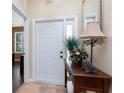 Welcoming foyer with a stylish table, decorated with flowers, and a beautiful mirror on the wall at 11343 Dancing River Dr, Venice, FL 34292