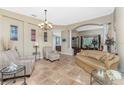 Spacious living room with tile flooring, neutral tones, and an open layout to the dining area at 11343 Dancing River Dr, Venice, FL 34292