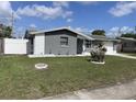 Single-story home with well-kept lawn, mature landscaping, and attached garage at 1144 Rushmore Dr, Holiday, FL 34690