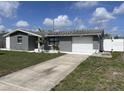 Single-story home with an attached garage featuring a well-maintained yard and mature landscaping at 1144 Rushmore Dr, Holiday, FL 34690