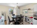 Dining area featuring a chandelier, modern furniture, and adjacent kitchen space at 13684 Orange Sunset Dr # 101, Tampa, FL 33618