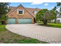 Charming brick home featuring a paved driveway and well manicured lawn under a sunny sky at 3269 Nicks Pl, Clearwater, FL 33761