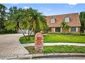 Charming brick home featuring a paved driveway and well manicured lawn under a sunny sky at 3269 Nicks Pl, Clearwater, FL 33761