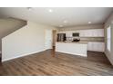 Open-concept living space with wood-look flooring that flows into a well-appointed kitchen at 36933 Sagemoor Dr, Zephyrhills, FL 33541