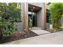 Contemporary home's front entrance boasts modern design, contrasted by lush, vibrant landscaping at 4148 Gauge Line Loop, Tampa, FL 33624