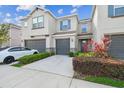 Charming townhome featuring a well-maintained lawn, a one-car garage, and stylish gray and blue accents at 6825 Citrus Creek Ln, Tampa, FL 33625