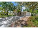Inviting one-story home with a lengthy driveway, lush lawn, and mature trees offering ample shade at 7003 Yule Ln, Tampa, FL 33637