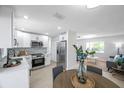 Bright, open kitchen with stainless steel appliances and modern finishes, flowing into living space at 8045 Colton Dr, Port Richey, FL 34668