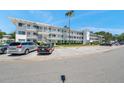 Three-story condo building featuring white facade, multiple balconies, and parking at 8396 111Th St # 301, Seminole, FL 33772