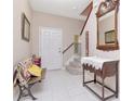 Bright foyer with tile flooring, stairs, bench, console table and neutral decor at 9317 Stone River Pl, Riverview, FL 33578