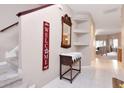 Elegant foyer with tile flooring, stairway, decorative mirror and a console table at 9317 Stone River Pl, Riverview, FL 33578