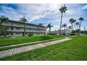Condominium complex with palm trees and sidewalk at 960 Virginia St # 204, Dunedin, FL 34698