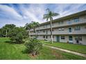 Exterior view of the condo buildings with open walkways and tropical landscaping at 960 Virginia St # 204, Dunedin, FL 34698