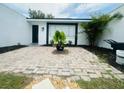 Home entrance featuring a brick-paved patio with a potted plant at 3516 Norland Ct, Holiday, FL 34691