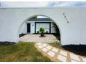 Exterior view framed by an archway, showcasing the home's entrance at 3516 Norland Ct, Holiday, FL 34691