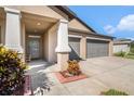 Inviting front exterior featuring a well-maintained lawn, a convenient two-car garage, and a welcoming front door at 10211 Cakebread Ln, Riverview, FL 33578