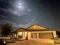 Exterior front view of single-story home at night showcasing the well-kept lawn, two-car garage, and cozy entrance at 10211 Cakebread Ln, Riverview, FL 33578