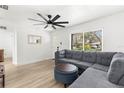 Comfortable living room with large window, plush sectional, and contemporary ceiling fan at 1275 Palm St, Clearwater, FL 33755