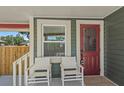 Charming front porch detail with seating and a red front door at 1435 Prescott S St, St Petersburg, FL 33712