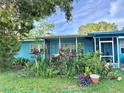 Landscaped yard showcases the exterior of this single story home with screened in porch at 1605 Logan St, Clearwater, FL 33755