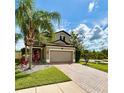Charming two-story home featuring a brick driveway, tropical landscaping, and a two-car garage at 19636 Long Lake Ranch Blvd, Lutz, FL 33558