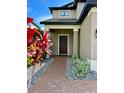 Inviting front entrance with a brick pathway, manicured landscaping, and a stylish front door with wreath at 19636 Long Lake Ranch Blvd, Lutz, FL 33558