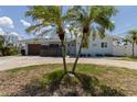 Inviting single-story home with palm trees and a well-manicured lawn at 2 79Th S St, St Petersburg, FL 33707
