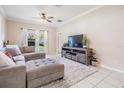 Spacious living room with neutral tones, ceiling fan, tile floors and cozy seating at 20302 Noble Oak Pl, Tampa, FL 33647