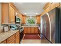 Modern kitchen featuring stainless steel appliances, granite countertops, and wood cabinets at 2110 W View Dr, Sun City Center, FL 33573