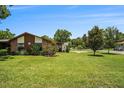 Charming single-story home with a well-manicured lawn and mature trees on a beautiful sunny day at 2270 Spruce Ln # B, Palm Harbor, FL 34684