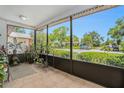 Relaxing screened porch with tiled flooring and a view of the landscaped front yard at 2270 Spruce Ln # B, Palm Harbor, FL 34684