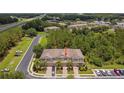 Aerial view of the townhomes showcasing the community, landscaping, and nearby lake and highway at 26835 Juniper Bay Dr, Wesley Chapel, FL 33544