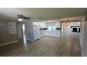 Spacious open-plan kitchen with white cabinets, modern appliances, and wood-look flooring at 3150 Beacon Square Dr, Holiday, FL 34691