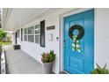 Detailed view of the home's bright blue front door adorned with a wreath and stylish accents at 3545 59Th N Ln, St Petersburg, FL 33710