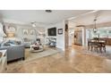 Open-concept living space with travertine floors connecting to a well-lit kitchen and dining area at 3545 59Th N Ln, St Petersburg, FL 33710