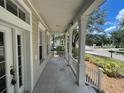 Inviting front porch with white railings and columns, offering a comfortable outdoor space and neighborhood view at 405 Islebay Dr, Apollo Beach, FL 33572