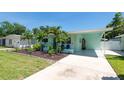 Light-blue home with a well-maintained yard, new landscaping, and a covered driveway at 4718 24Th S Ave, St Petersburg, FL 33711