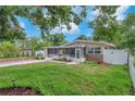 Charming home featuring well-manicured lawn, landscaped garden beds, and a screened-in porch at 4731 W Leila Ave, Tampa, FL 33616
