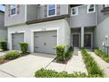 Exterior view of the townhome's entry, with manicured bushes along the walkway and a gray garage door at 5110 Sylvester Loop, Tampa, FL 33610