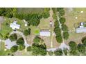 Aerial view of the property showcasing multiple buildings, surrounding trees, and pond access at 5613 Forest Creek Rd, Lakeland, FL 33810