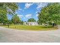 Quaint home on a spacious corner lot with mature trees, a well-maintained lawn, and a mailbox at 5613 Forest Creek Rd, Lakeland, FL 33810