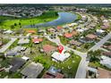 Stunning aerial view of a home near a lake, nestled in a vibrant community with a mix of colorful rooftops and lush greenery at 602 Deep Lake Ln, Sun City Center, FL 33573