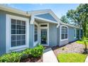 Inviting home entry with stylish windows, a well-maintained walkway, and attractive landscaping at 6044 Sandhill Ridge Dr, Lithia, FL 33547