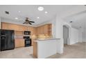Bright kitchen featuring wood cabinets, black appliances, and a breakfast bar at 6044 Sandhill Ridge Dr, Lithia, FL 33547