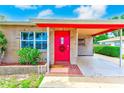 Inviting front entrance with a bright red door, brick accents, and a covered carport at 6237 50Th N Ave, St Petersburg, FL 33709