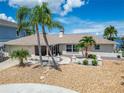 Charming single-story home with a well-maintained front yard, stone walkway, landscaping and pink accents at 6334 Cocoa Ln, Apollo Beach, FL 33572