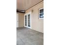 Exterior view of back patio with tiled flooring and sliding glass doors with window at 7107 Hernando Ct, Tampa, FL 33615