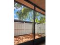 A relaxing screened in back porch with a wooden fence and a palm tree visible at 7107 Hernando Ct, Tampa, FL 33615